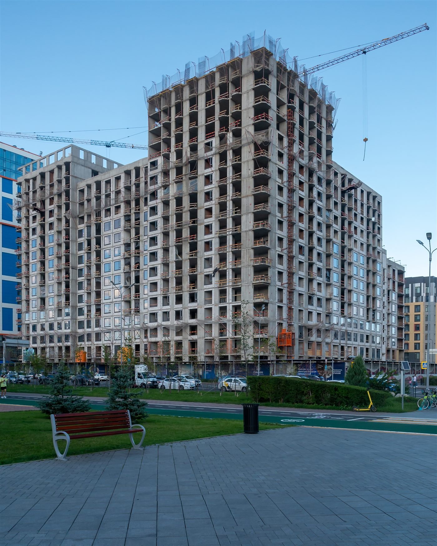 High-rise building under construction with a tower crane, daytime