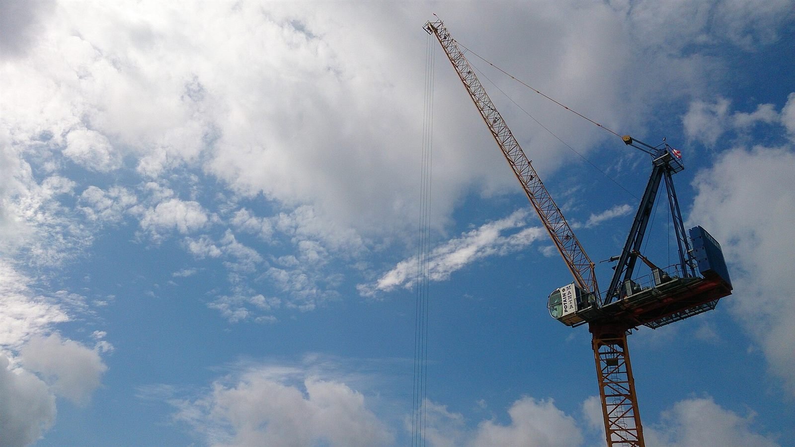 Tower crane against a clear blue sky at an active construction site