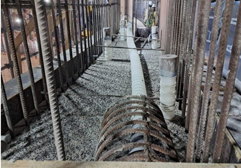 Night shot of workers in a rebar-cage corridor with lighting