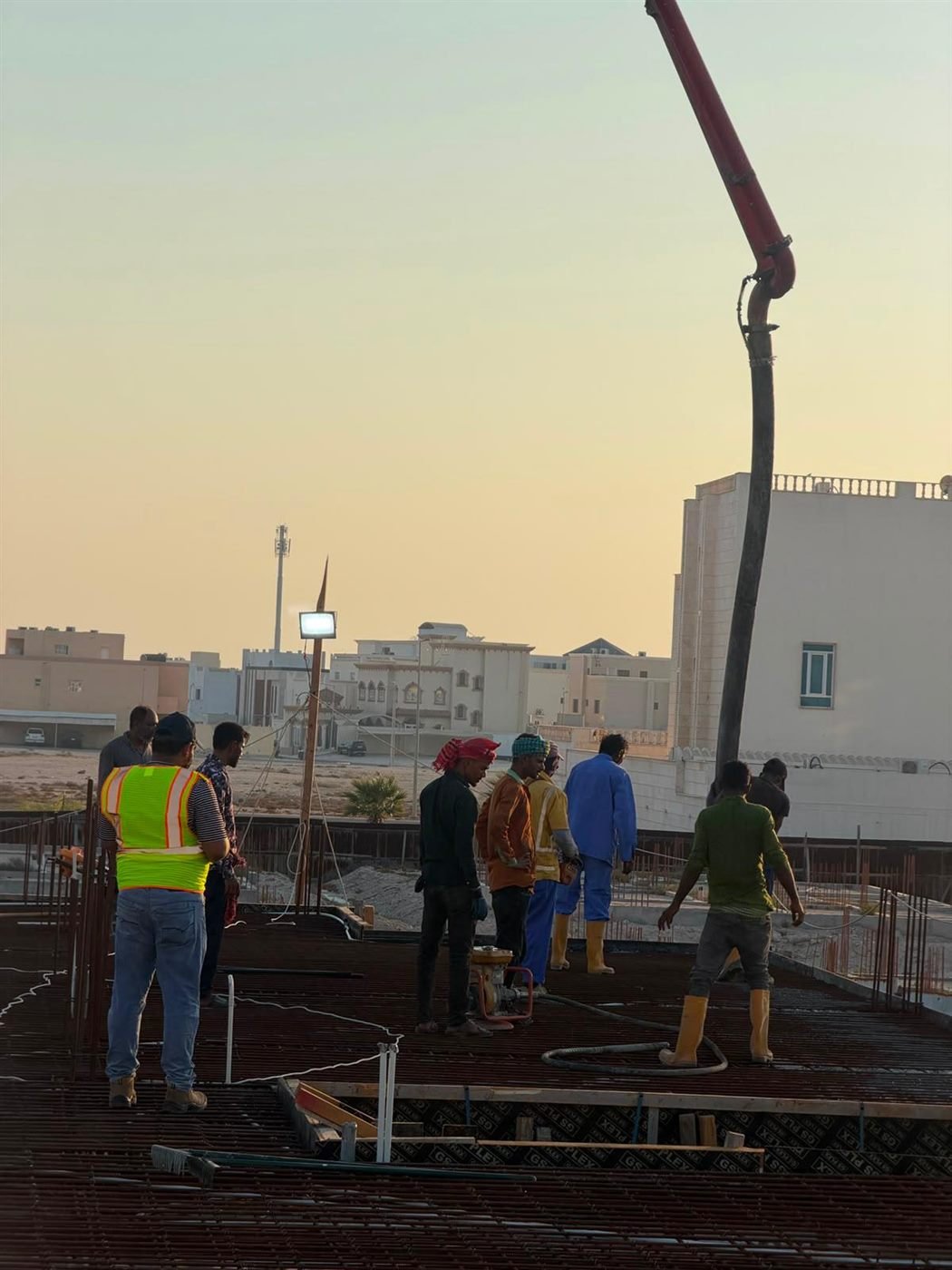 Crew wrapping up a concrete pour at dusk